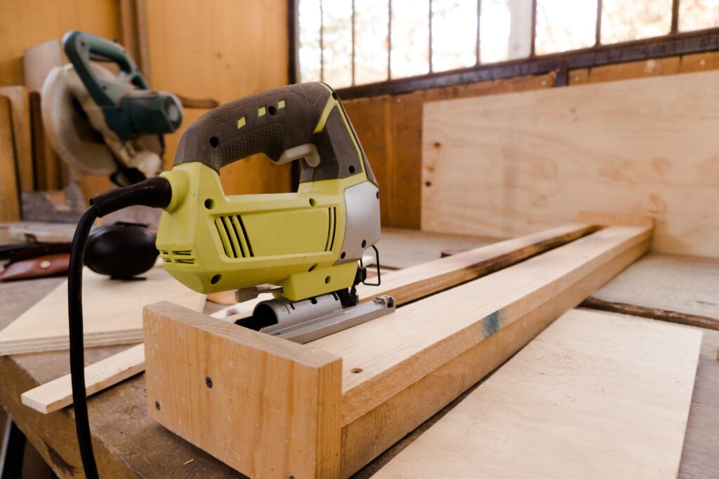Plywood pieces cut out and nailed together on a workbench.